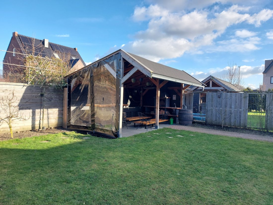 Strak gespannen verandazeil aan de zijkant van een veranda in de tuin