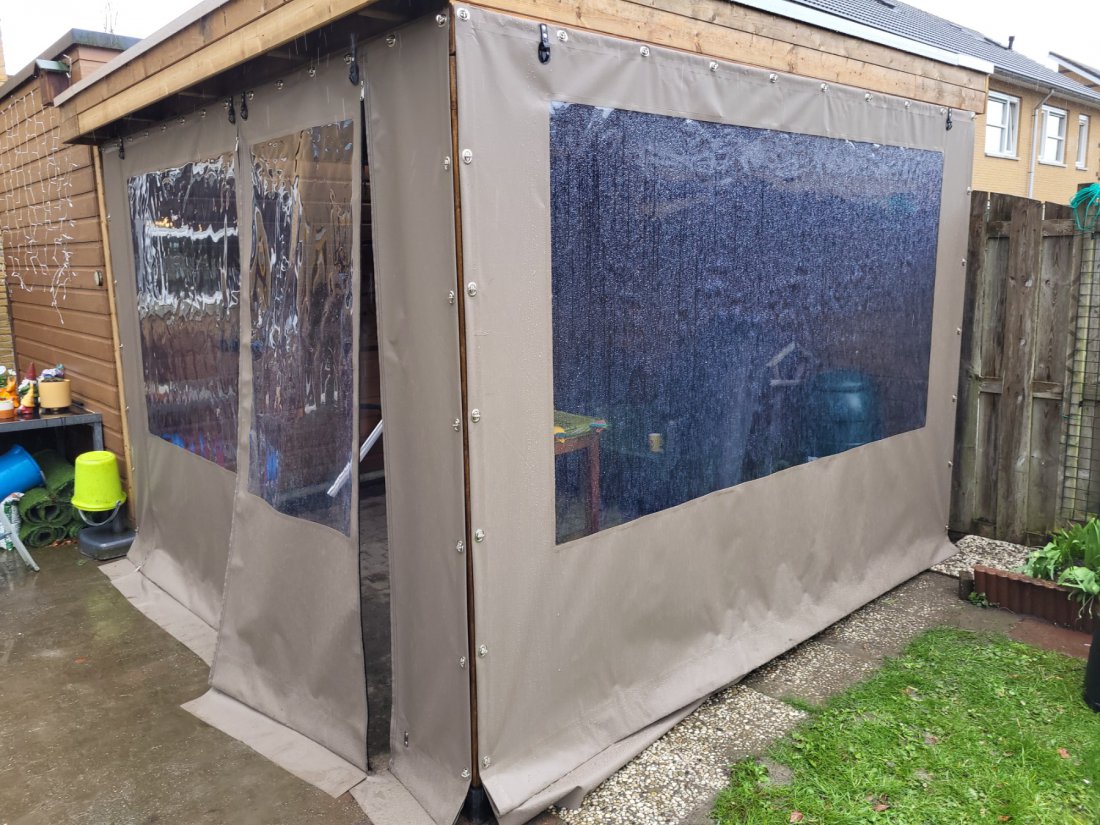 Verandadoek rond een overkapping klaar voor winteropslag Verandadoek op maat rond een overkapping, opgevouwen en klaar voor de winteropslag