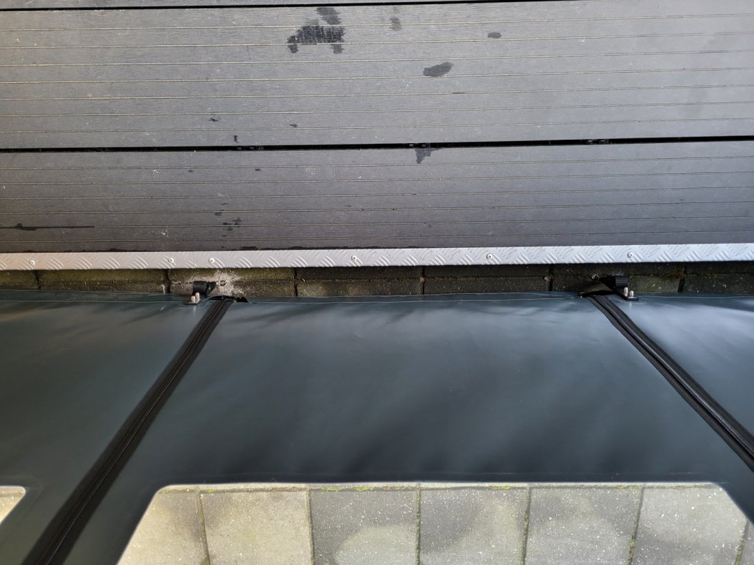 Onderzoom van een verandadoek met spanband Onderzoom van een verandadoek met spanband om klapperen te voorkomen