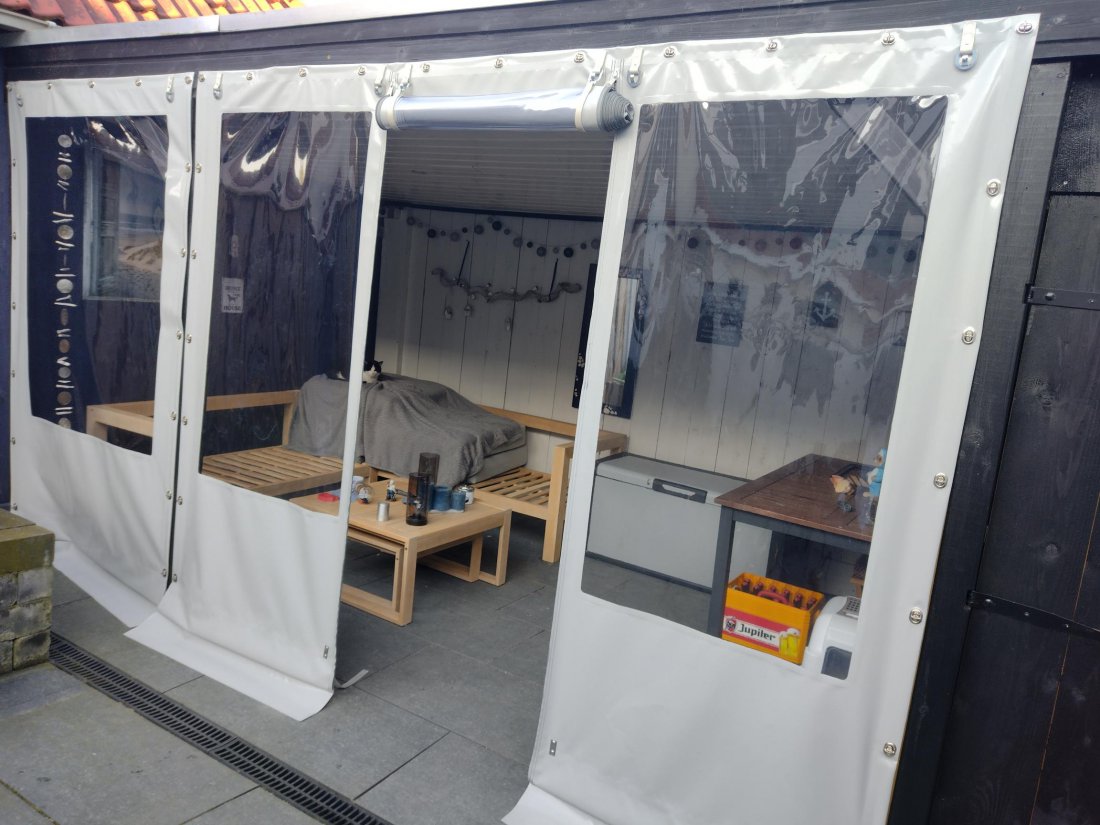 Verandazeil van transparant pvc met witte banen rond een overkapping